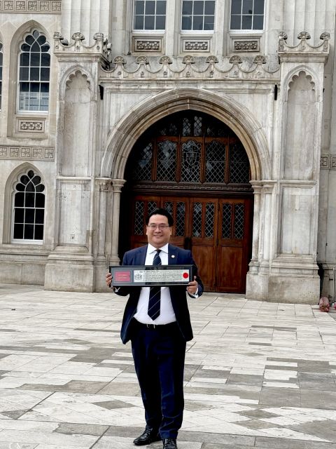 Dr. Glenn Agung Hole with the Freedom of the City of London scroll in front of Guildhall, London