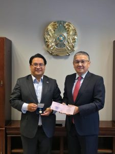 Dr. Glenn Agung Hole receiving the honorary professorship in Kazakhstan